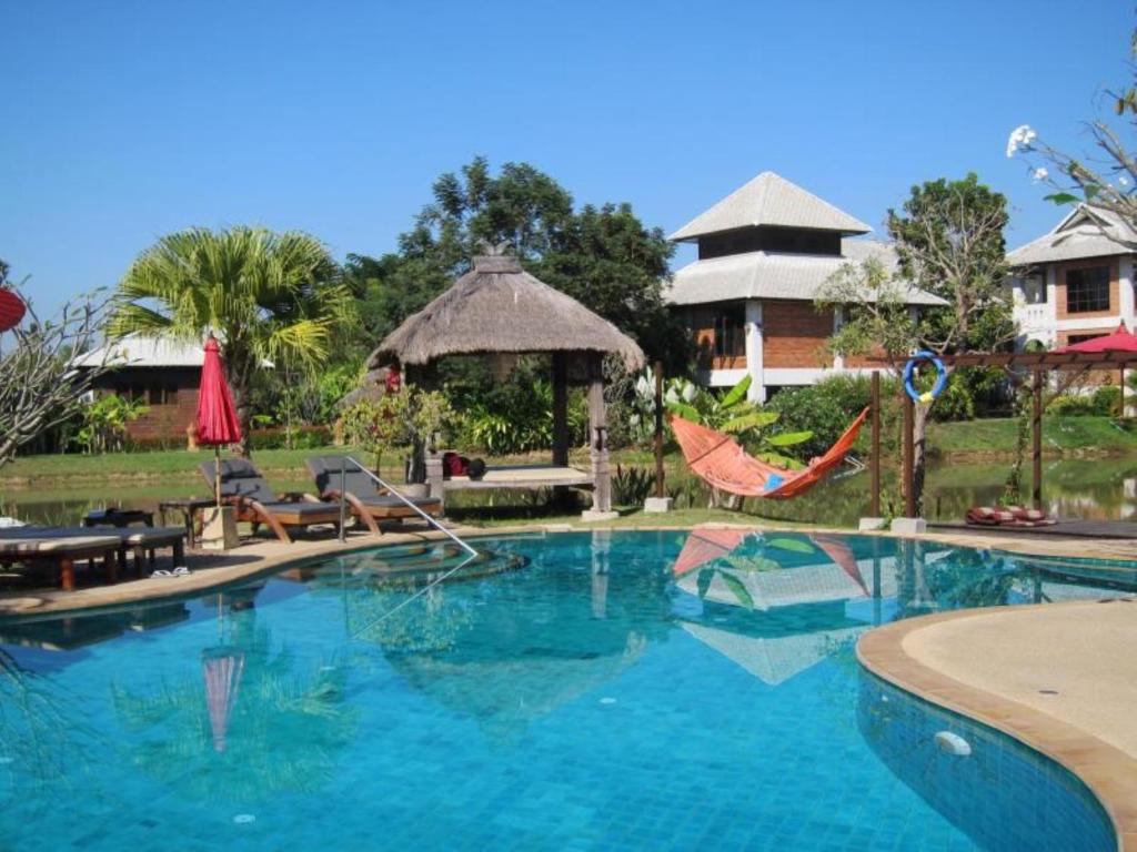 - une piscine avec un hamac et un complexe dans l'établissement Baan Chai Thung Resort, à Doi Saket