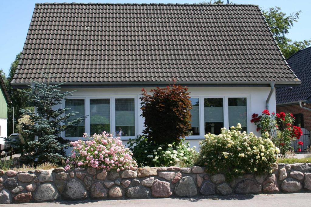 a house with a stone wall and some flowers at Ferienhaus Frey in Eggebek