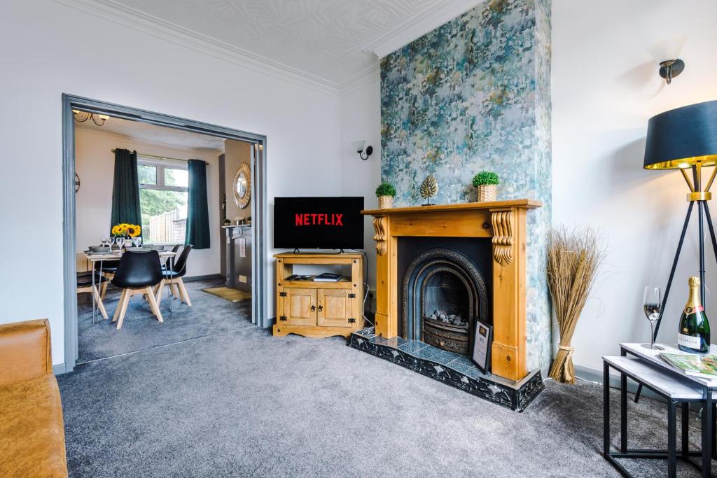 ein Wohnzimmer mit einem Kamin und einem TV in der Unterkunft Ideal for CONTRACTORS & WORKERS, Long-term discounts - 4-Bed House in Crewe by 53 Degrees Property - Sleeps 8 in Crewe
