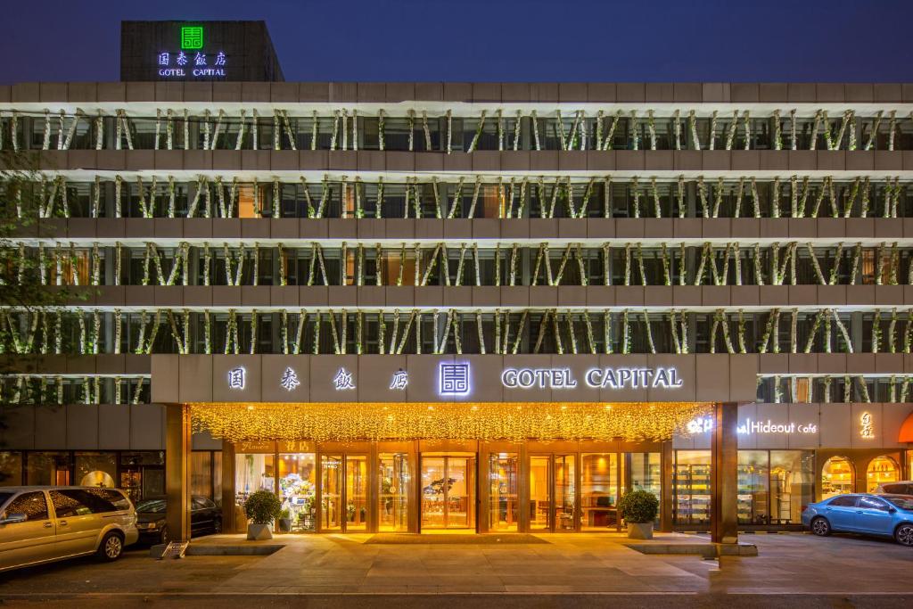 un edificio con coches estacionados frente a él en Gotel Capital, en Beijing