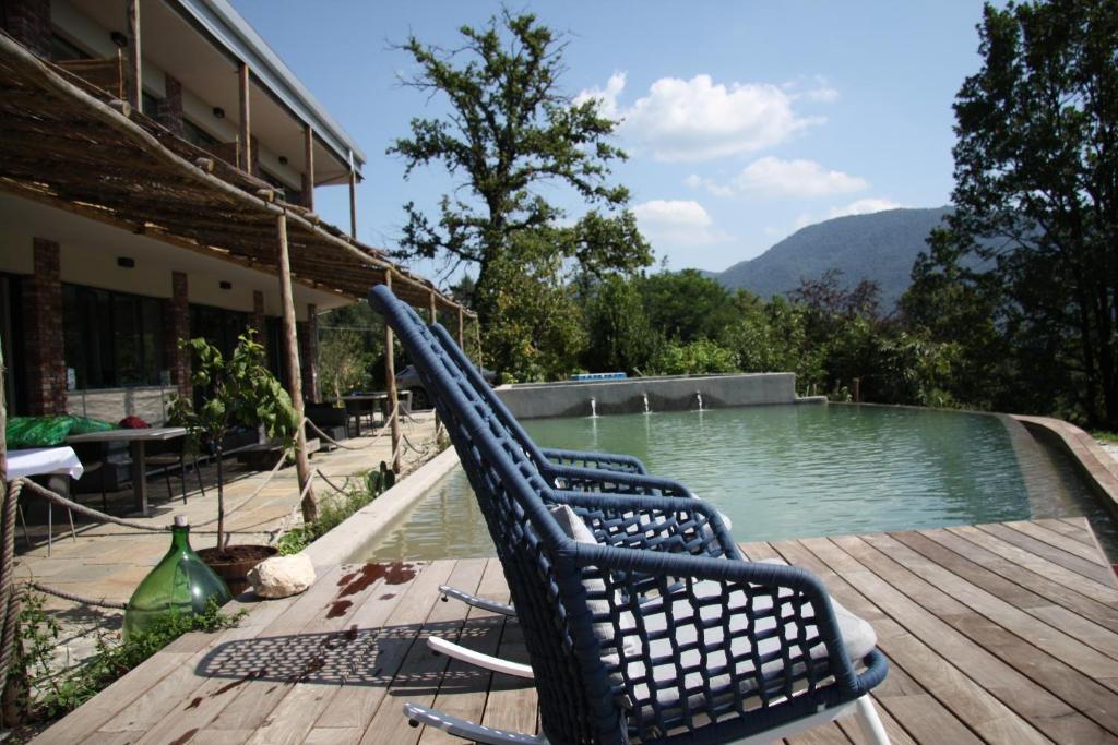 a chair sitting on a deck next to a swimming pool at Agriturismo Voeuja Lago Maggiore in Luino