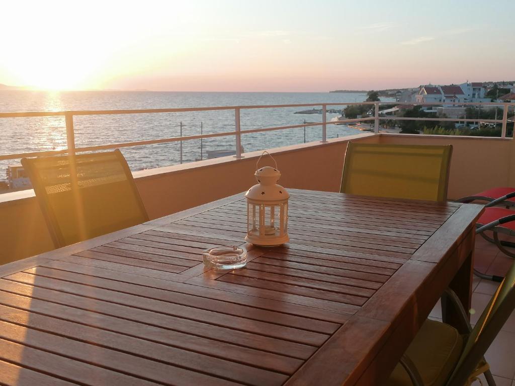 een houten tafel met een lantaarn bovenop een boot bij Apartments Villa Ema in Zadar