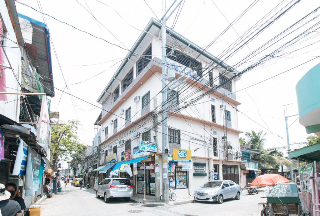 a street with cars parked in front of a building at RedDoorz at MBB Room NAIA 2 in Manila