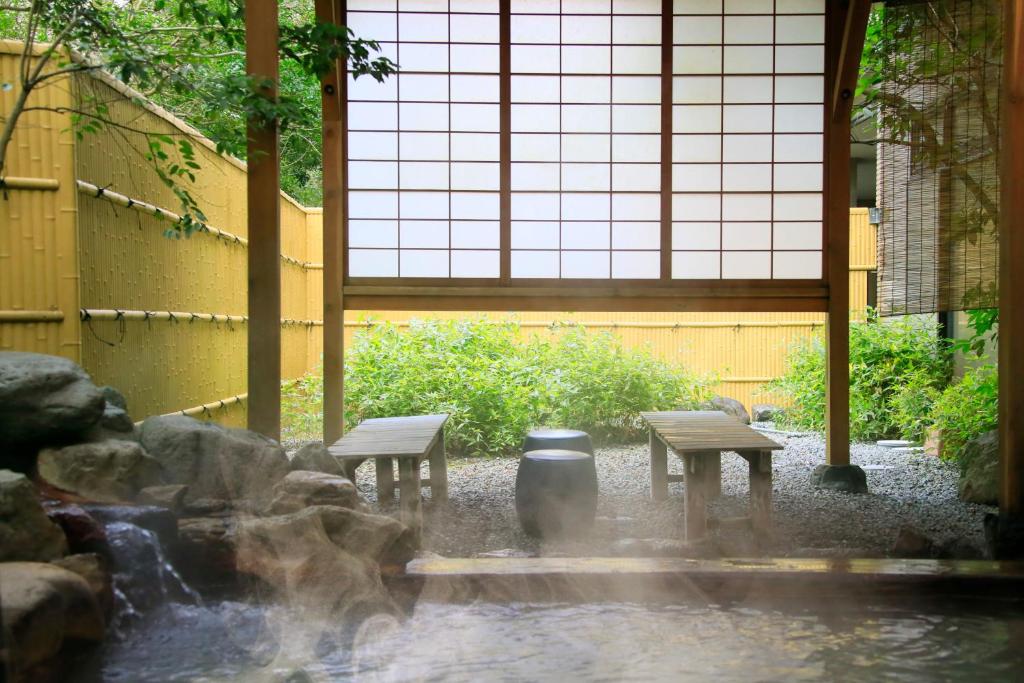 zwei Bänke und ein Brunnen in einem Gebäude in der Unterkunft EN RESORT Re'Cove Hakone in Hakone