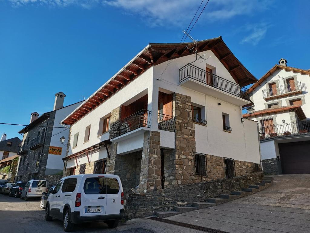 una furgoneta blanca estacionada frente a un edificio en Casa Tía María, en Ansó