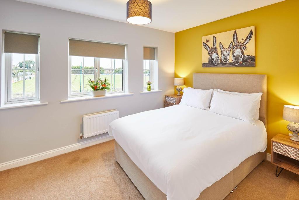a bedroom with a large white bed and windows at Host & Stay - Vermont in Marske-by-the-Sea