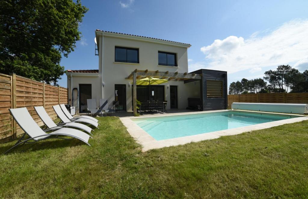 a house with a swimming pool in the yard at La Foret d'Armotte in Saint-Augustin