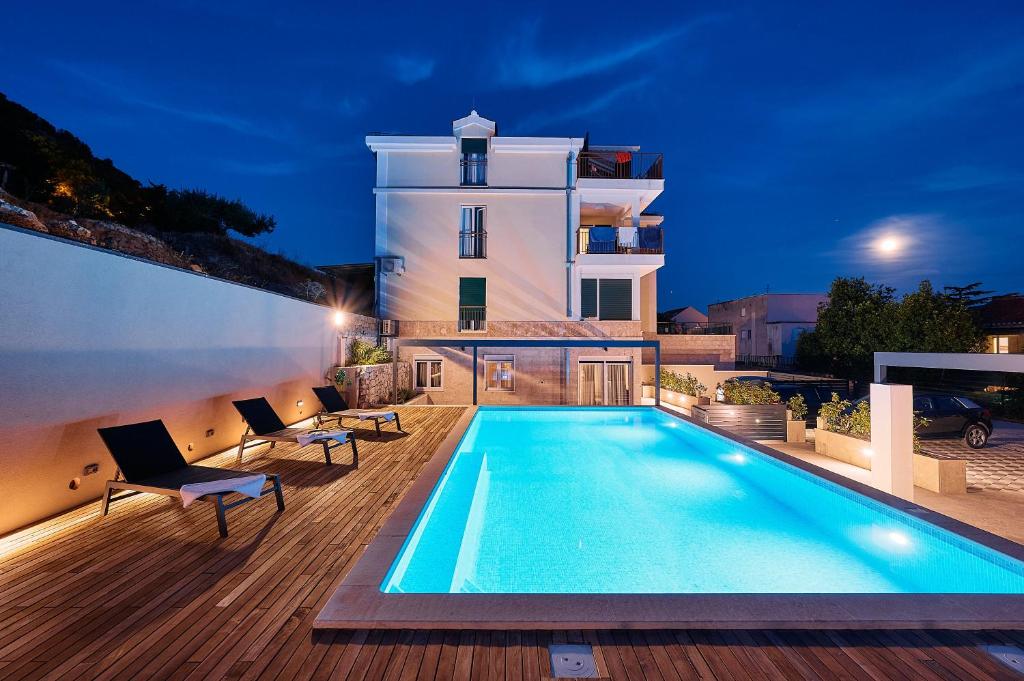 a villa with a swimming pool in front of a building at Sun Spalato Hills in Split