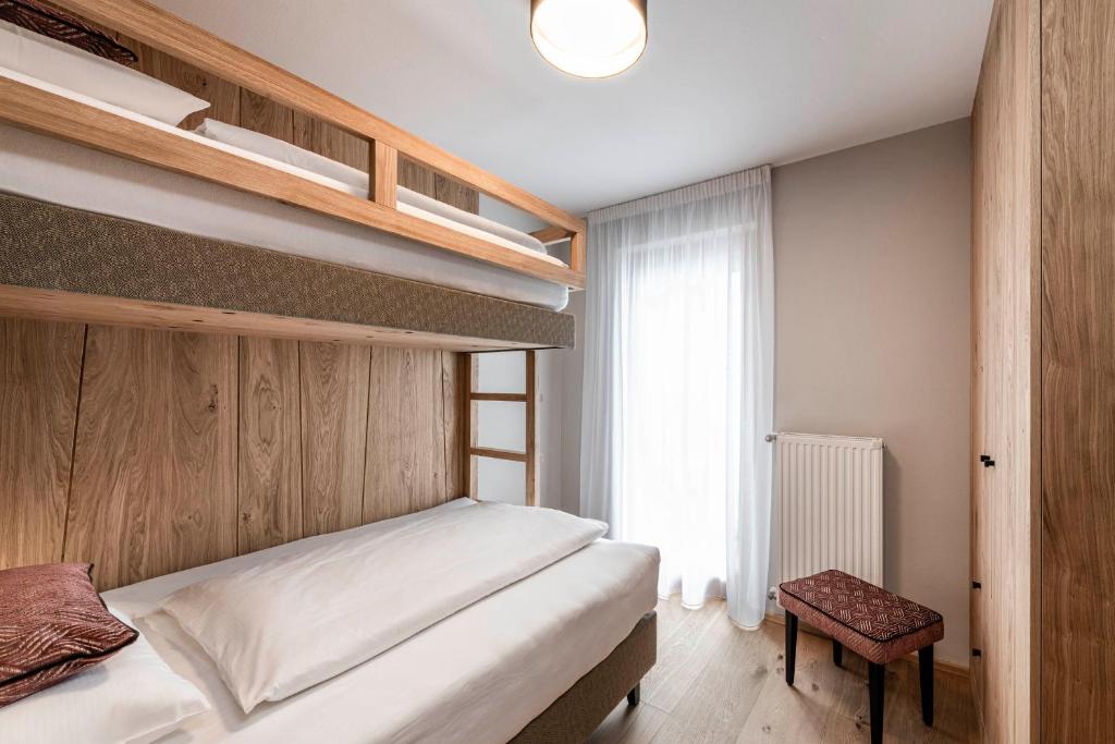sypialnia z łóżkiem piętrowym i oknem w obiekcie LaMonte Premium Apartments by Feuerstein w mieście Gossensass-Colle Isarco