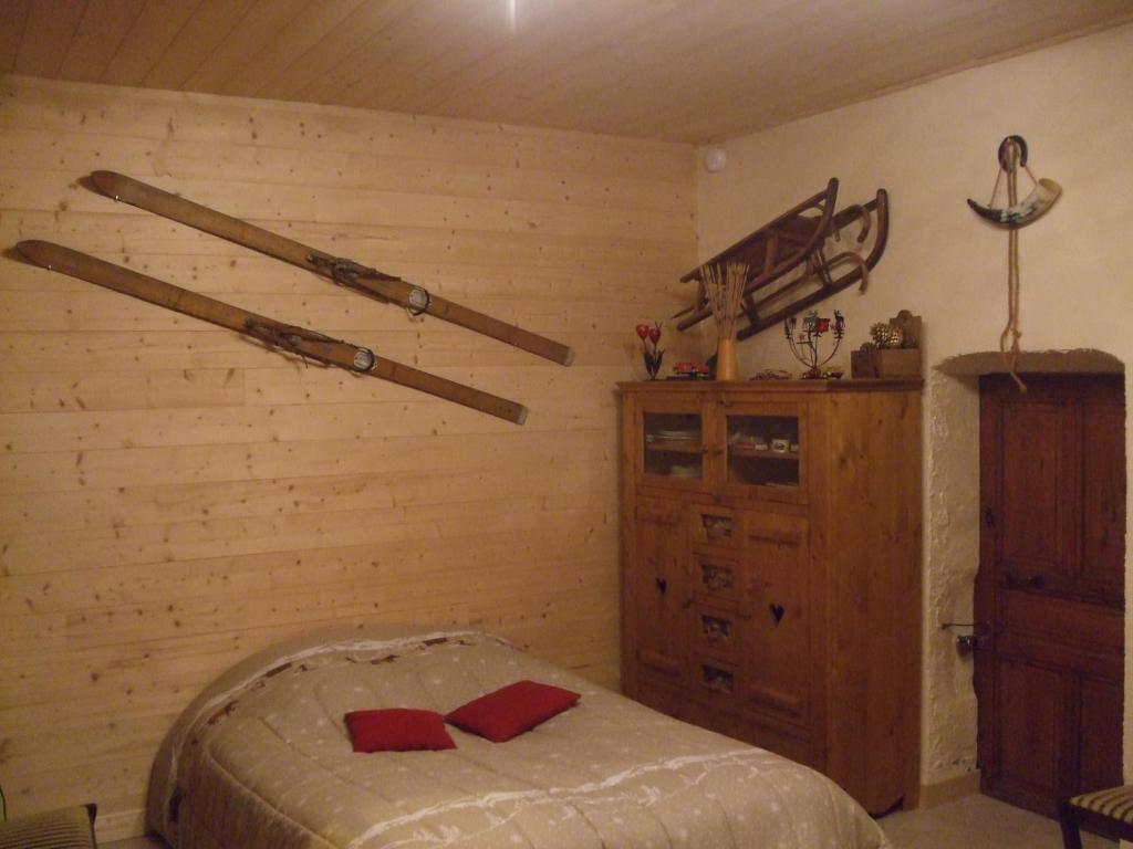 1 dormitorio con cama y bates de béisbol en la pared en Chalet montagne 11 p Grand Massif 100 m télécabine, en Morillon