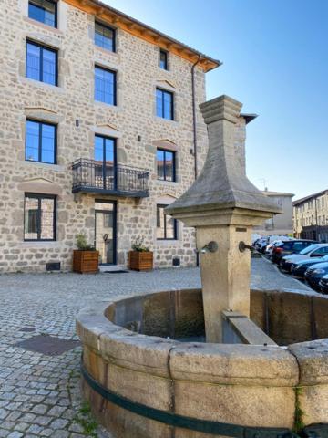 uma fonte de água em frente a um edifício em La Bâtisse du Velay em Saint-Didier-en-Velay