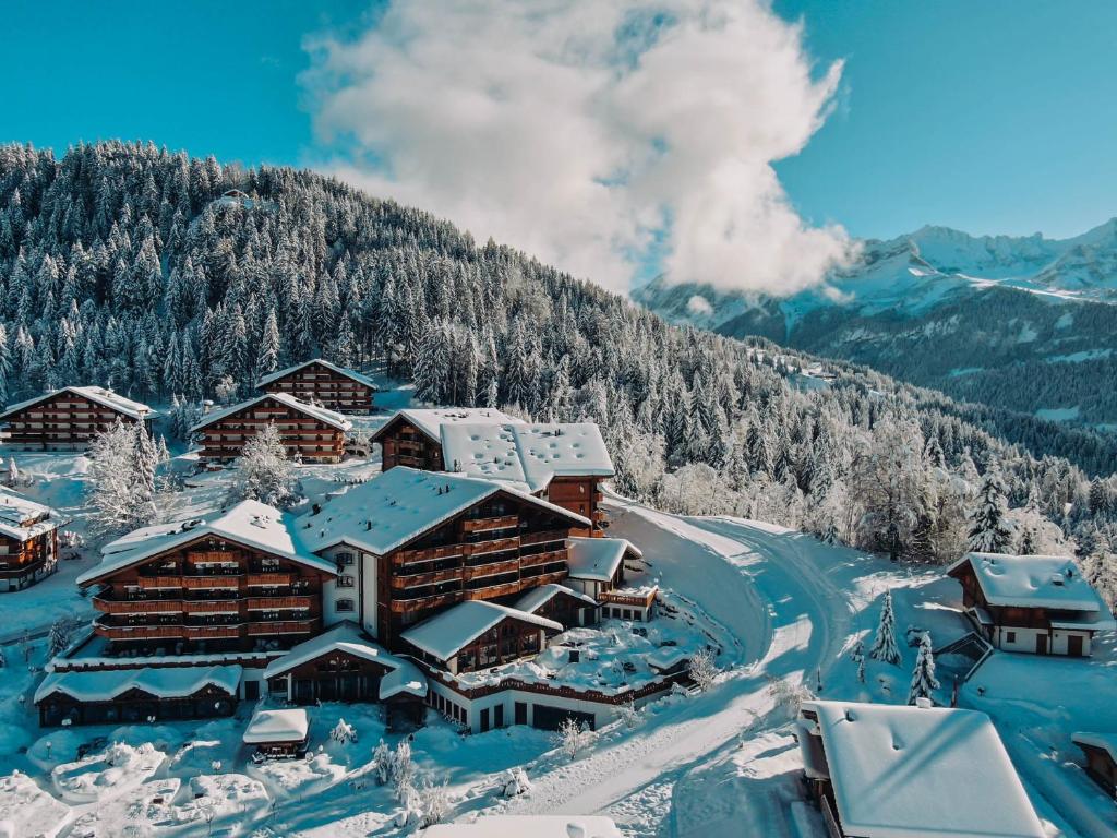 snow covered mountains and a cabin on a ski slope at Chalet RoyAlp Hôtel & Spa in Villars-sur-Ollon