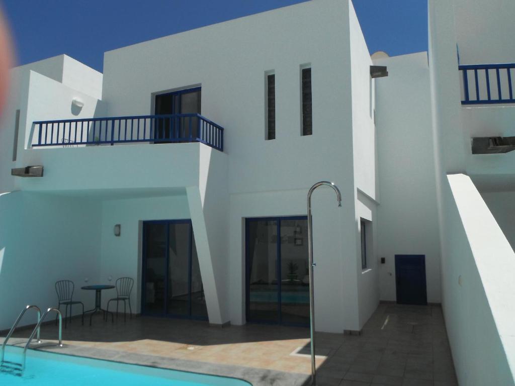 una casa con piscina y un edificio en Villa Maria, en Playa Blanca