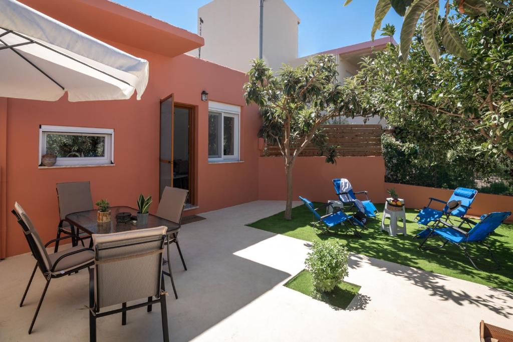 a patio with a table and chairs in a yard at Casa EleMar Villa with Private Yard in Hersonissos