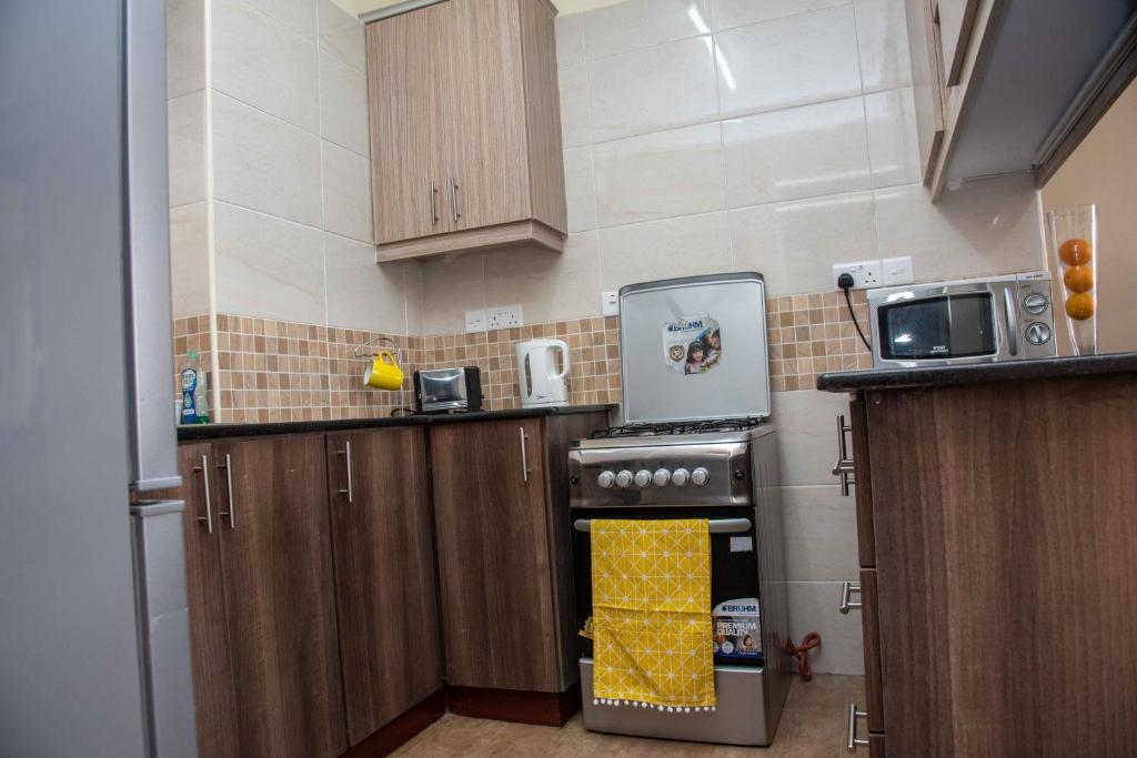 a small kitchen with a stove and a microwave at Westlands place 1 bedroom - Safari House, Sherry Homes in Nairobi