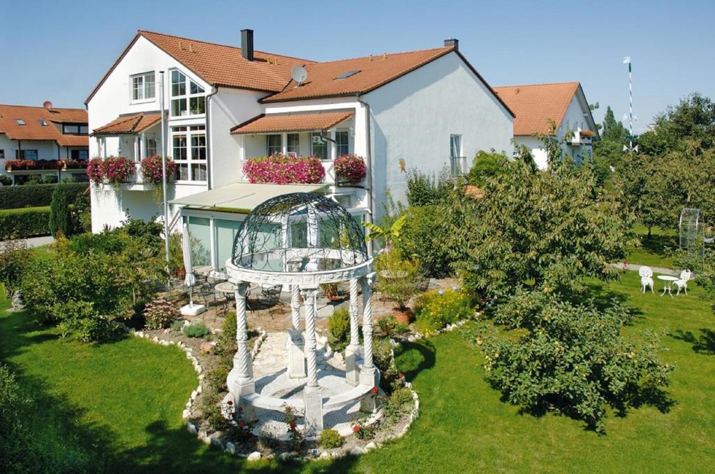 a garden in front of a house with a bird cage at Pension Martinus in Neustadt an der Donau