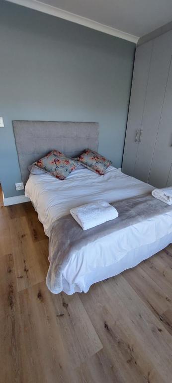 Kortrijk Paarl Self Catering في بارل: سرير عليه وسادتين في غرفة