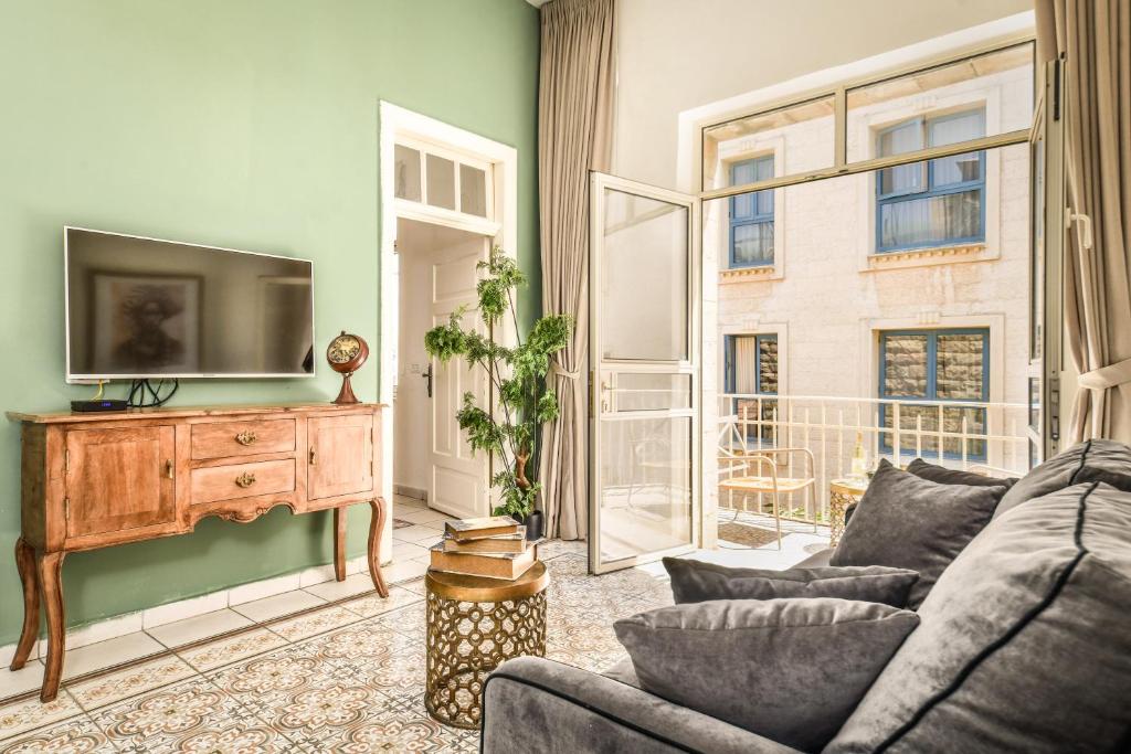 a living room with a couch and a tv at Mamila Pearl, Near Old City in Jerusalem