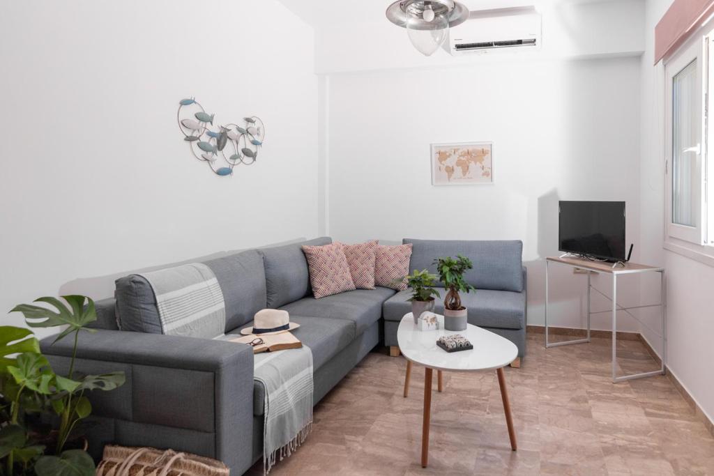 salon z niebieską kanapą i stołem w obiekcie Casa EleMar Villa with Private Yard w mieście Hersonissos