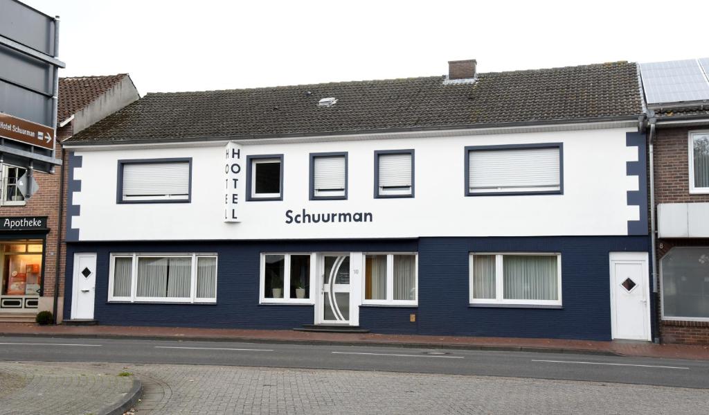 un edificio blanco y azul en una calle en Hotel Schuurman, en Emlichheim