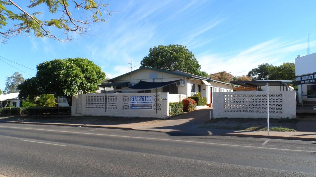 a white fence in front of a house at Star Inn Accommodation in Mount Isa