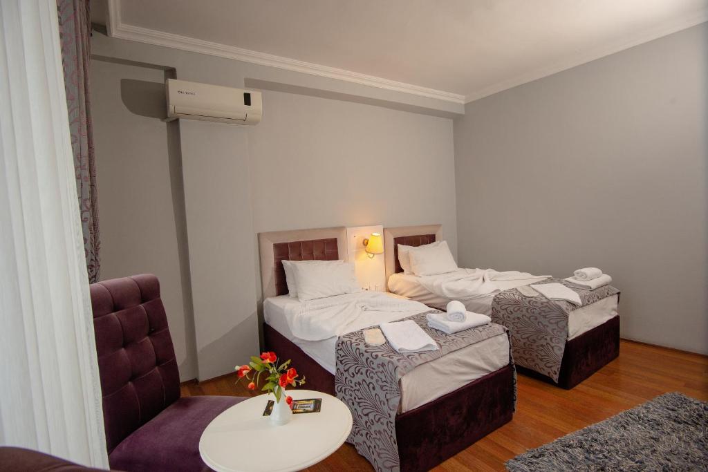 Habitación de hotel con 2 camas y mesa en SRF Hotel, en Eskisehir