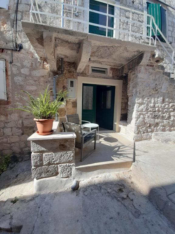 a stone house with a bench and a table at Violet in Vis