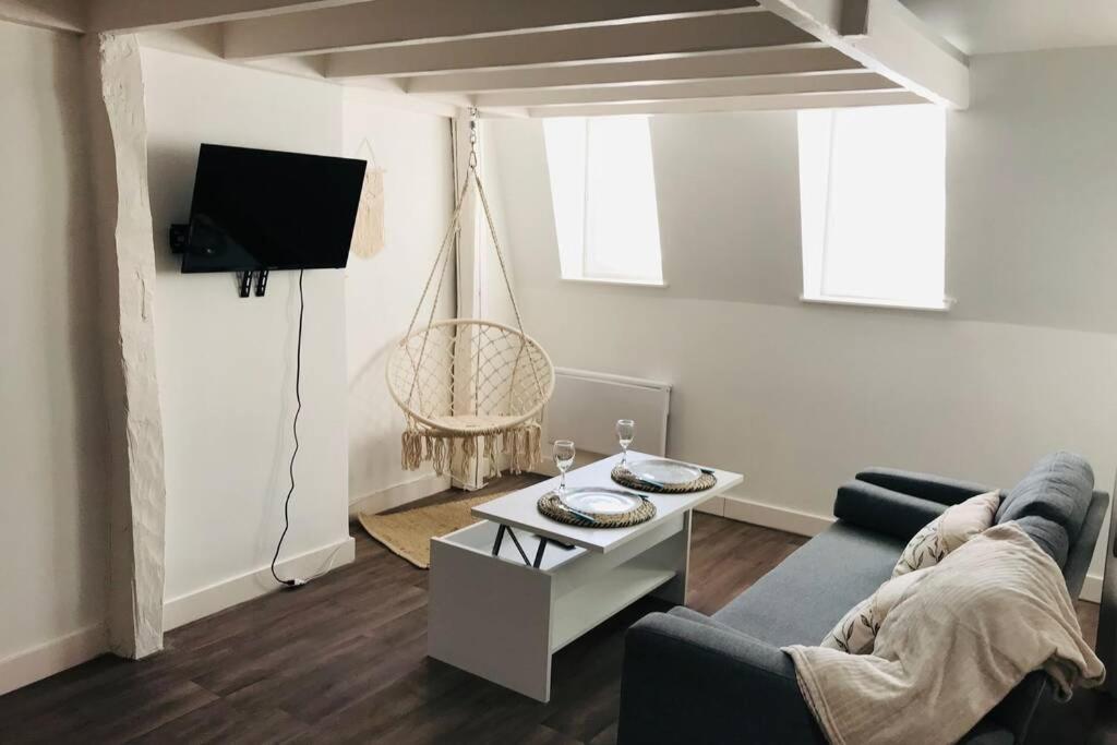 a living room with a couch and a table at Le Cosy bohème Abbeville baie de Somme in Abbeville