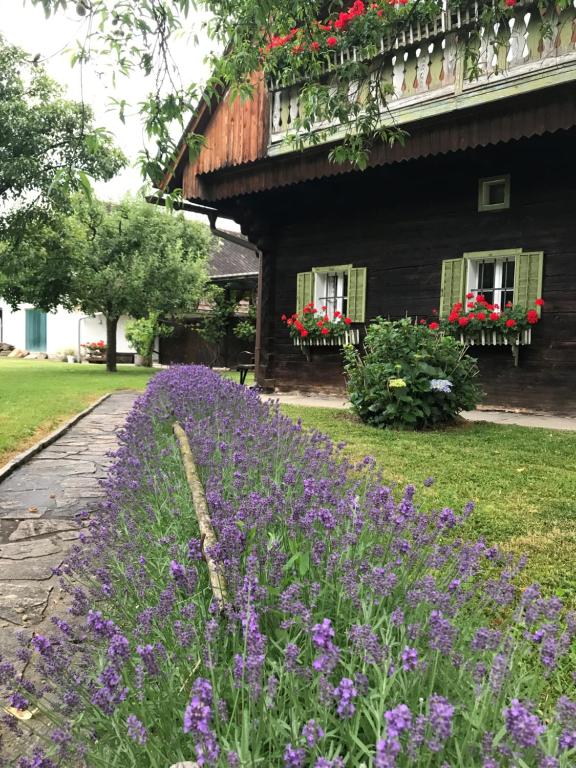 a garden with purple flowers in front of a house at Bauernhaus Süd- West- Steiermark für Radfahrer, Familien- und Feste mit Freunden in Sankt Martin im Sulmtal