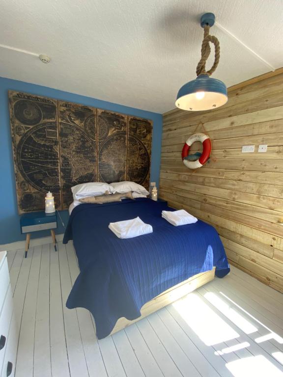a bedroom with a bed with a blue comforter at The Lobster Shack in Criccieth