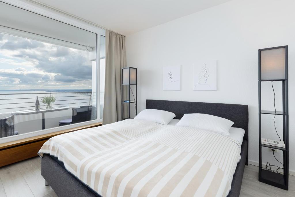 1 dormitorio con cama grande y ventana grande en Sky 347, en Timmendorfer Strand