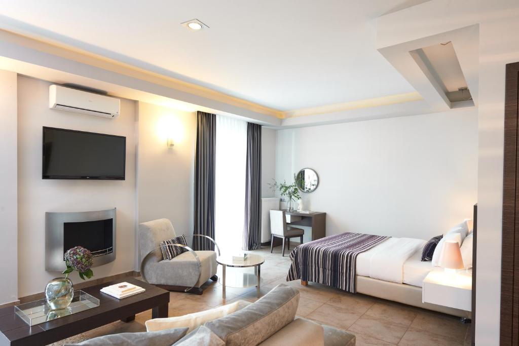 Habitación de hotel con cama y sala de estar. en Maison Hotel en Halkidona