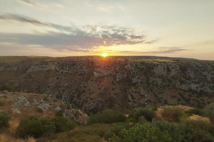 eine Luftansicht auf den Sonnenuntergang auf einer Klippe in der Unterkunft Appartamento La Chiesetta in Matera