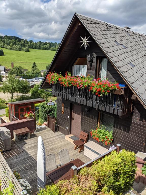 ein Haus mit einem Balkon mit Blumen darauf in der Unterkunft Ferienhaus an der Fichtelbergbahn in Cranzahl