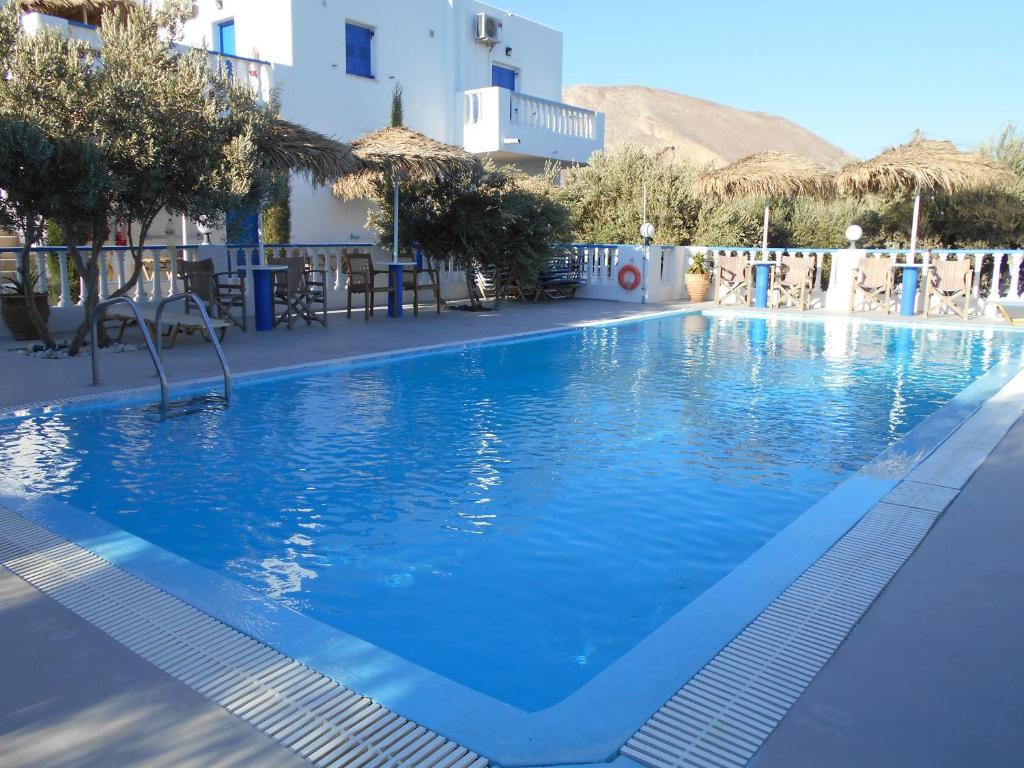 a large swimming pool with blue water in a resort at Studios Apartments Kapetanios in Perissa