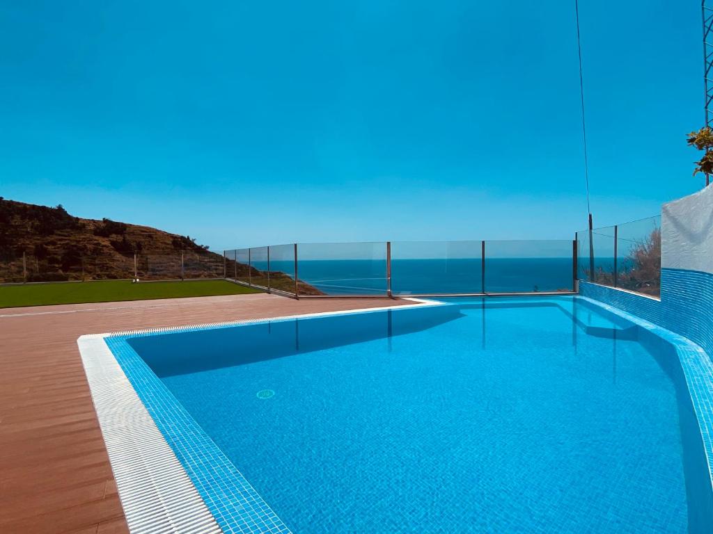 a swimming pool with a view of the ocean at Villas Calhau da Lapa 51 in Campanário