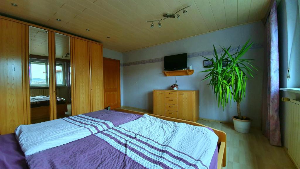 Un dormitorio con una cama morada y una planta en FreiRaum en Obersinn