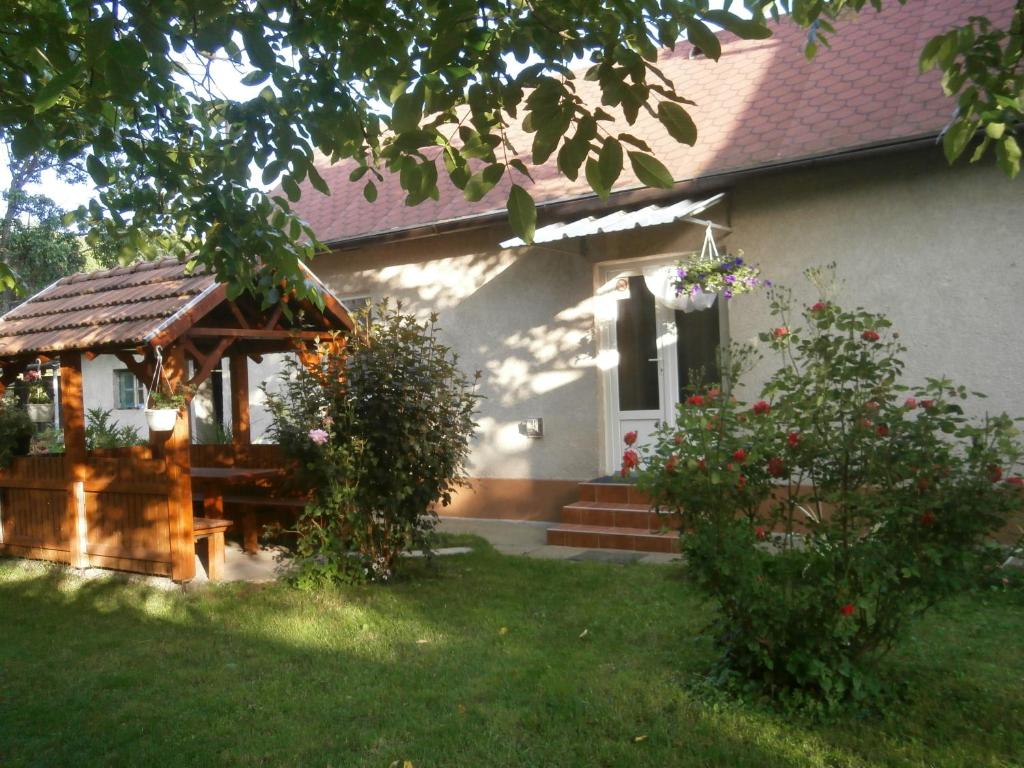 a white house with a gazebo in the yard at Csikász Vendégház in Nagyvisnyó