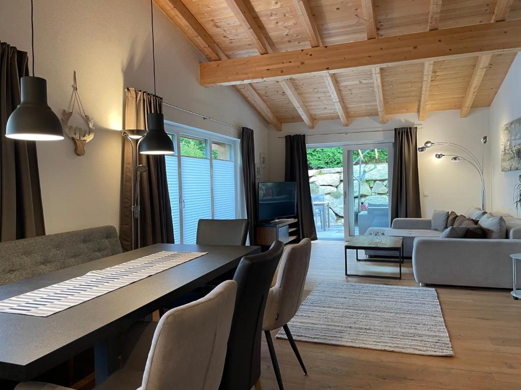 eine Küche und ein Wohnzimmer mit Tisch und Stühlen in der Unterkunft Chalet Hackl in Sautens