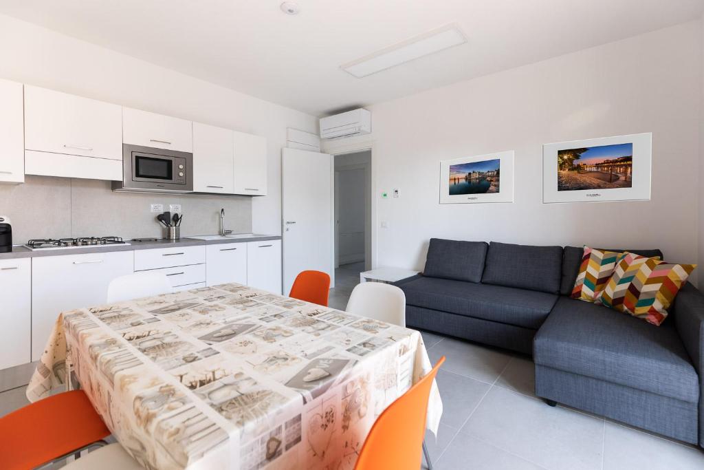 a kitchen and a living room with a table and a couch at Verona Suites in Verona