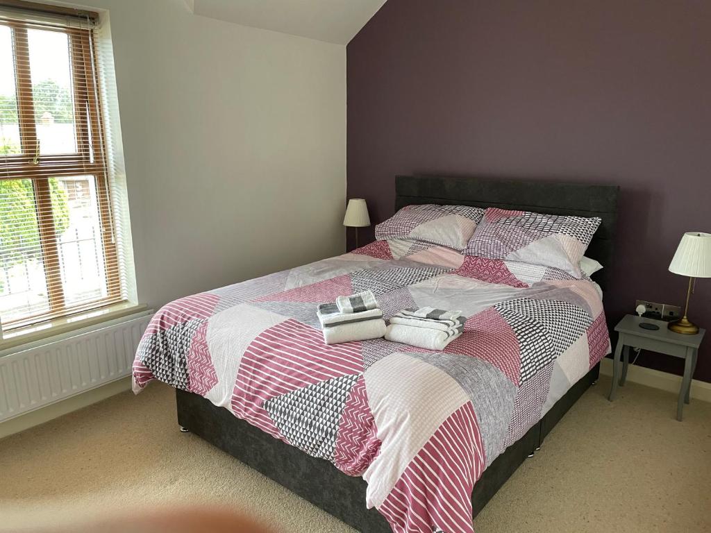 a bedroom with a bed with two bags on it at Orchard Oasis, Luxury Penthouse Getaway in Coleraine