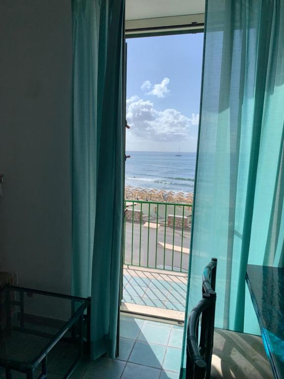 Zimmer mit Blick auf den Strand durch ein Fenster in der Unterkunft Appartamenti Lungomare Circeo in San Felice Circeo
