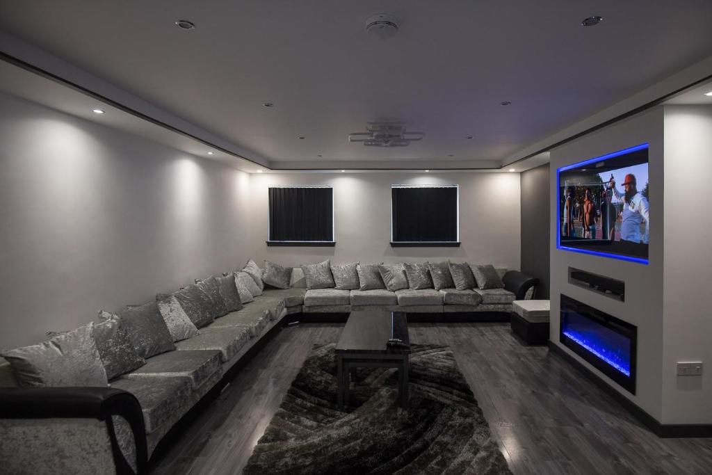 een woonkamer met een grote bank en een flatscreen-tv bij Waterfront luxury apartment in Kinghorn