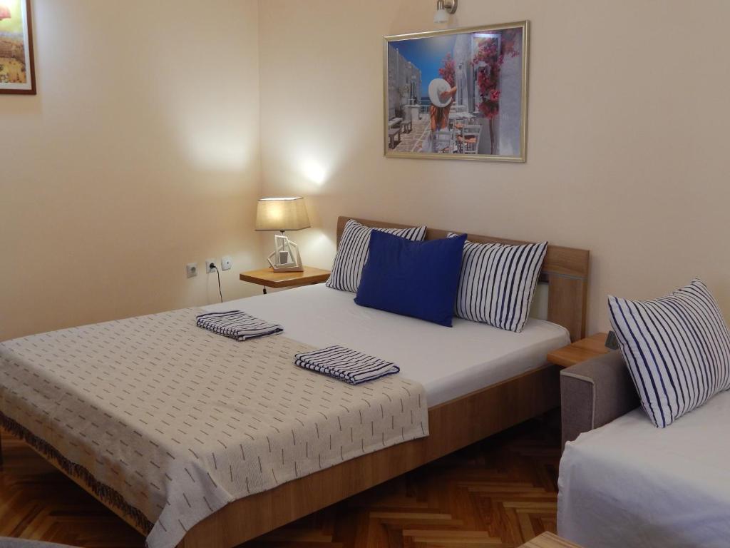 a bedroom with two beds with blue and white pillows at Apartmani Jelica FREE PARKING in Vranje