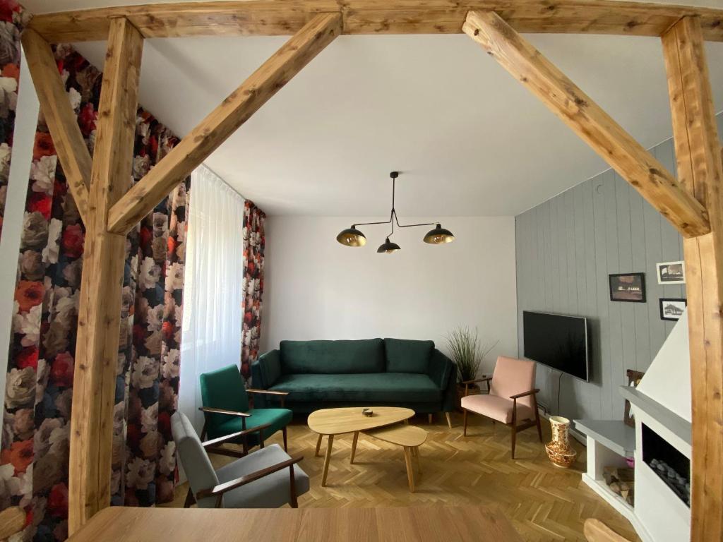 a living room with a green couch and a table at Rynek_28 in Ciężkowice