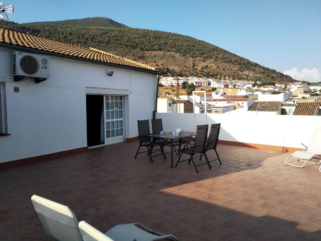 un patio avec des chaises et une table sur le toit dans l'établissement Alojamientos Andalucia, à Algodonales
