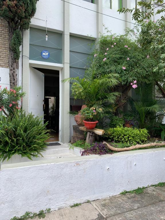 una entrada a un edificio con flores y plantas en A Una cuadra de La Minerva, en Guadalajara
