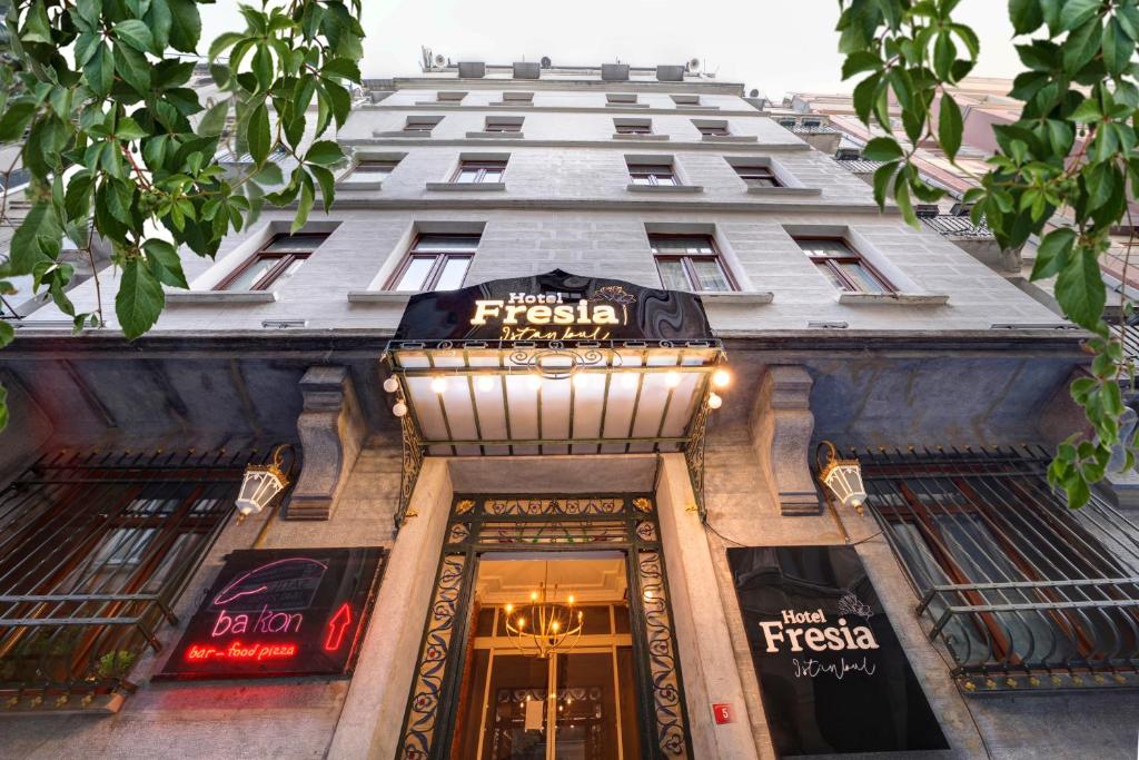 un gran edificio con una señal sobre la entrada de una tienda en Hotel Fresia Istanbul, en Estambul
