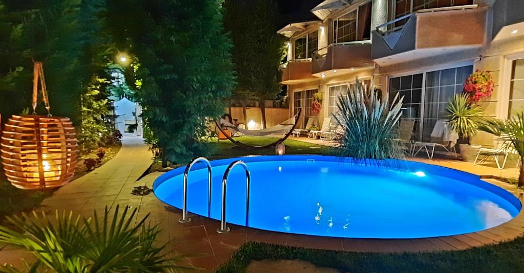 una piscina en el patio de una casa por la noche en Aloha Luxury Apartments, en Skopje