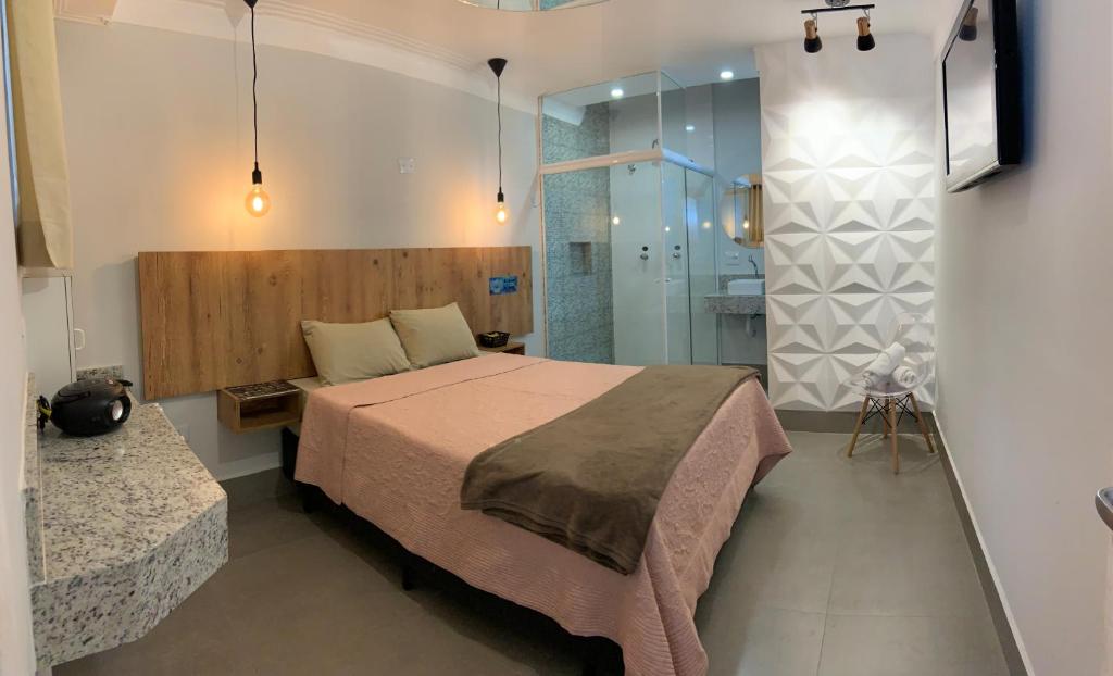 a bedroom with a large bed and a shower at Bob Motel in Sao Paulo